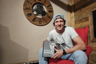 Kevin Lötscher pose avec un exemplaire du livre dans lequel il raconte son histoire et comment il s'est relevé de son accident.